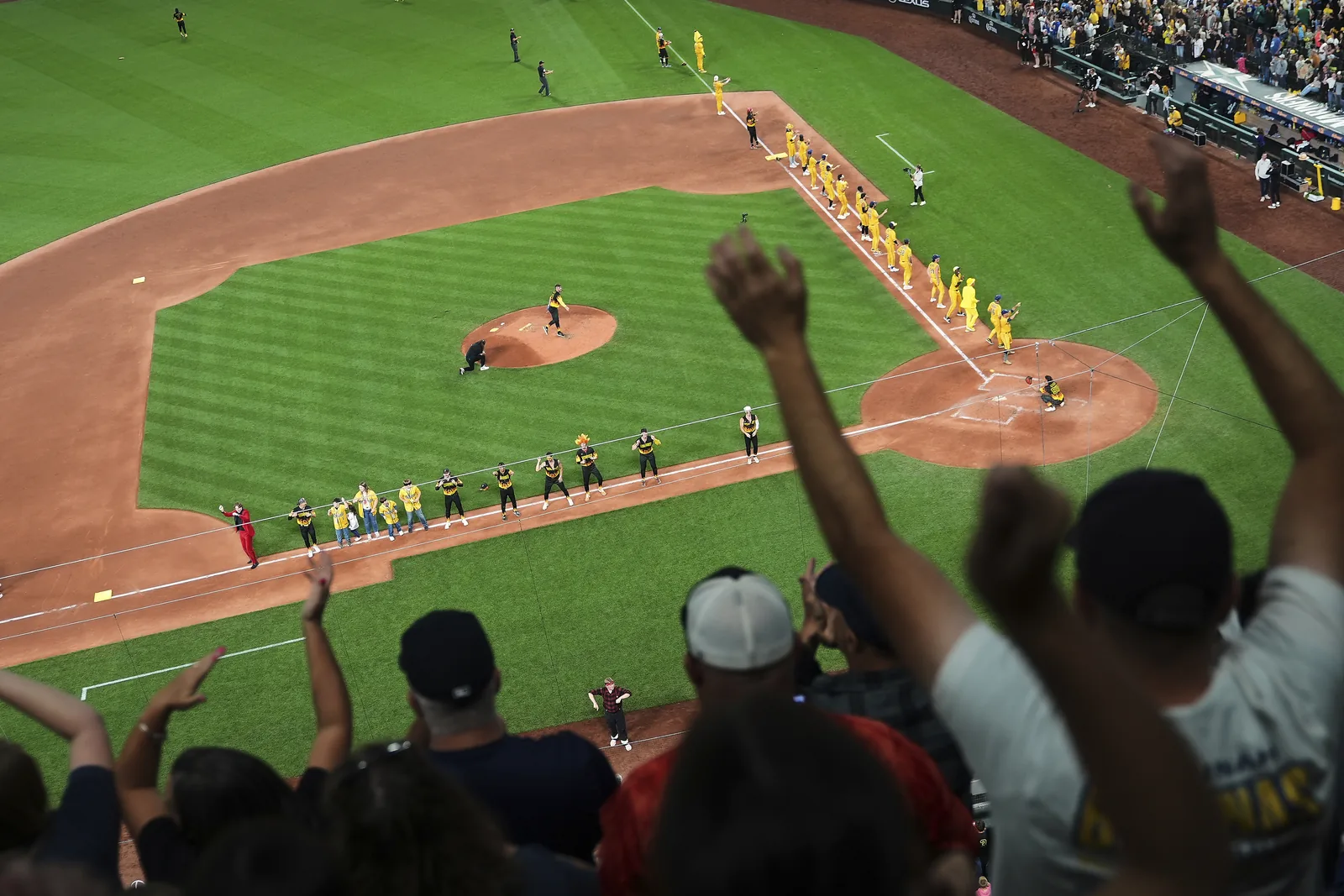 Savannah Bananas and Firefighters players dancing together on the field in Seattle