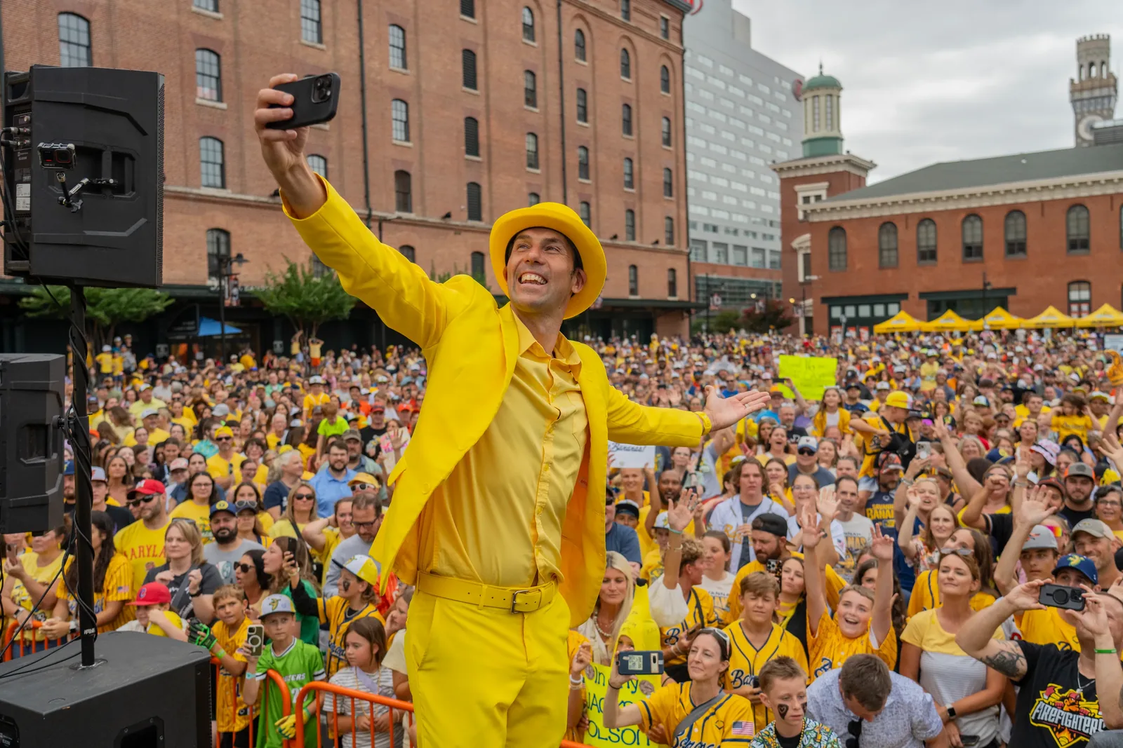 Jesse Cole takes a phone selfie with a large crowd of Banana Ball fans in Baltimore